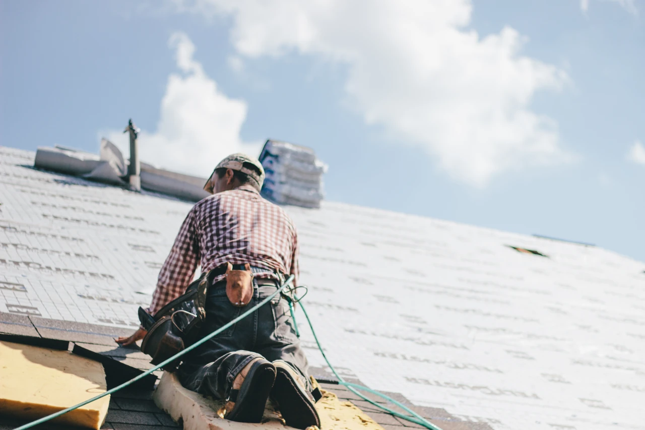 Roofer installing shingles