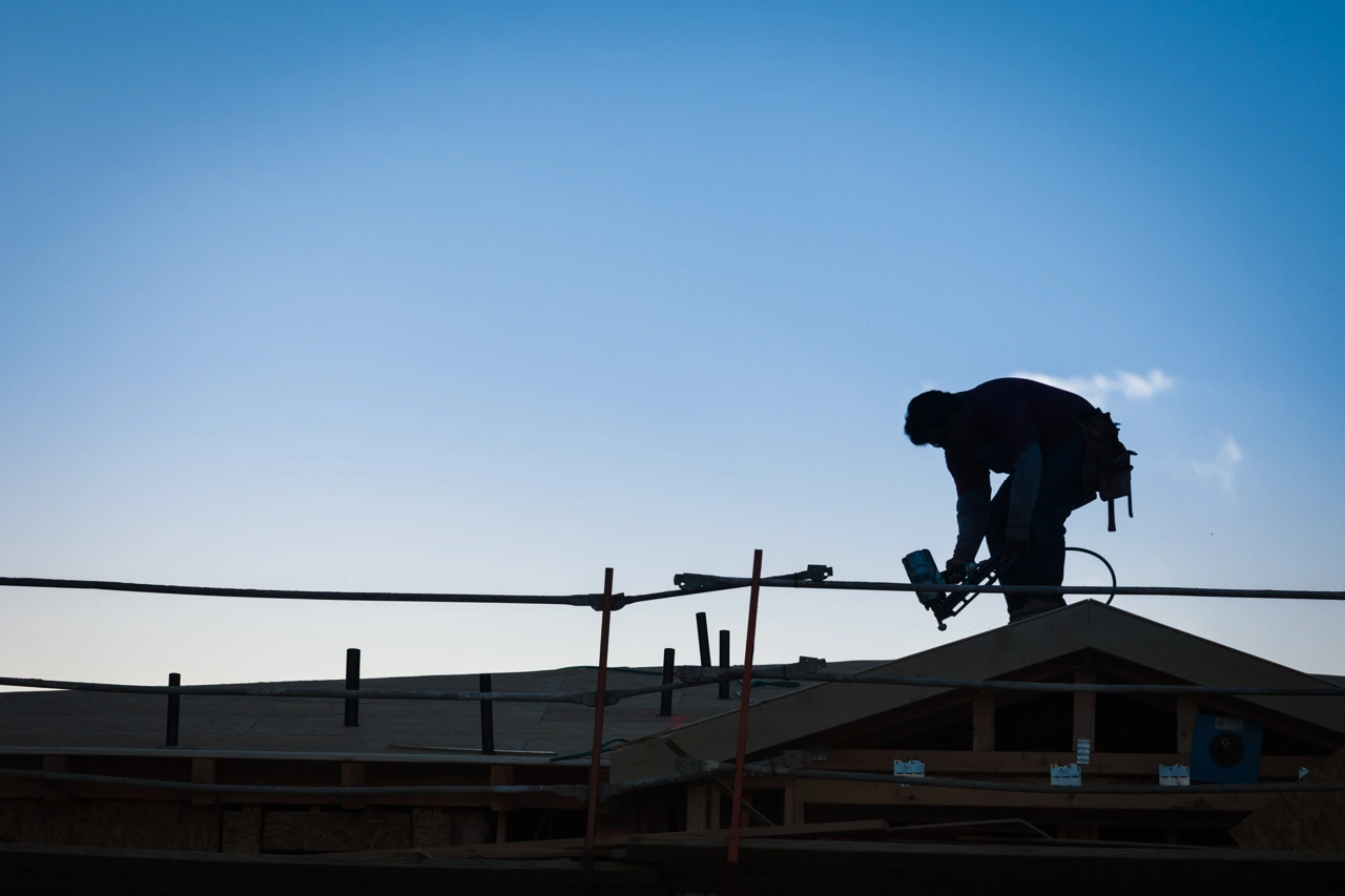 Construction worker silhouette on a roof