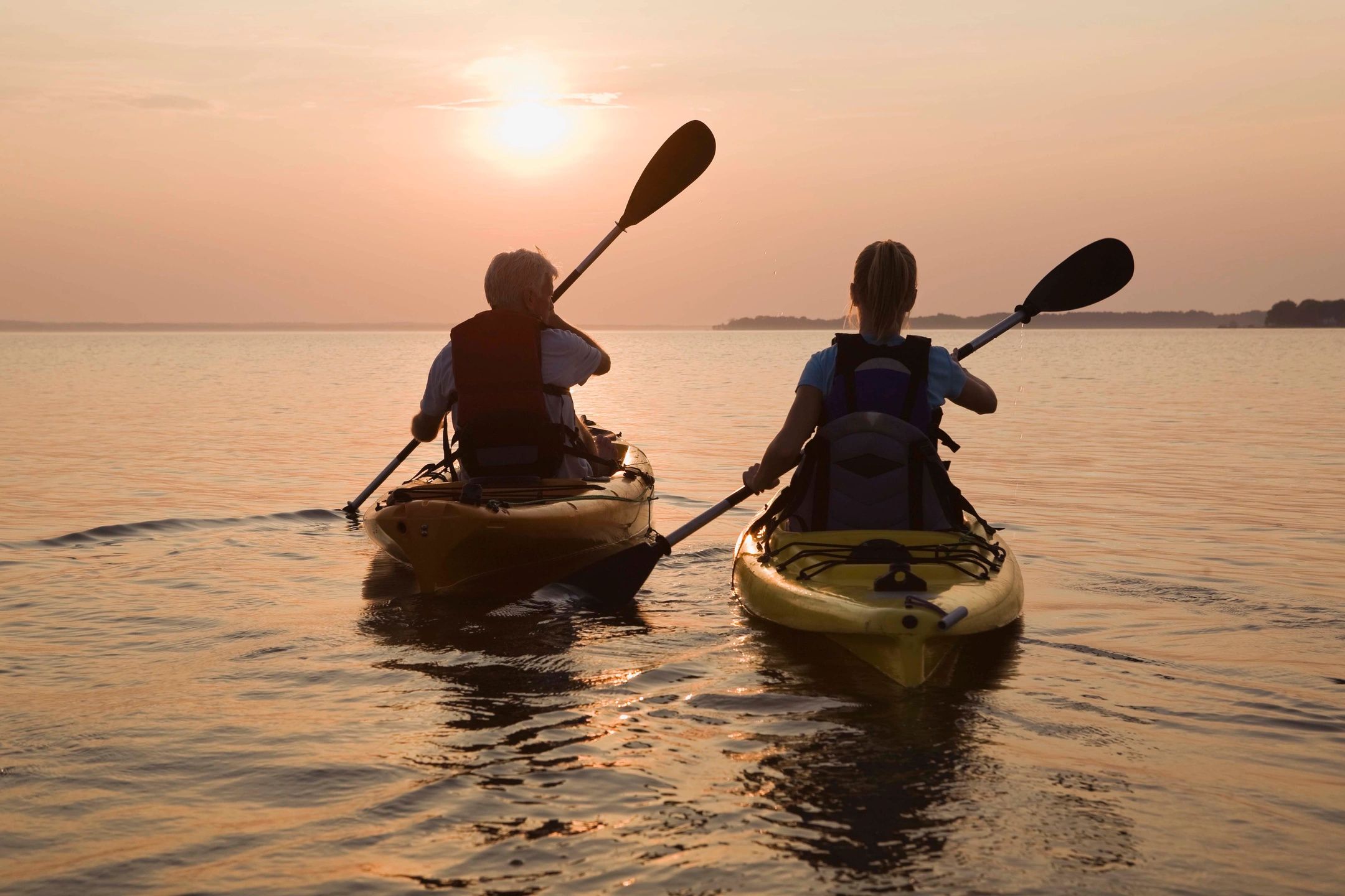 Expert guide teaching a child how to paddle a kayak